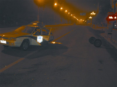 警车车身严重受损，后车轮被撞飞，车轱辘滚出五六米远。记者 成熔兴 摄