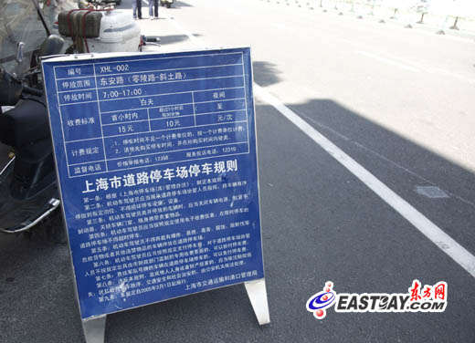 图片说明：事发路段设置的停车收费告示牌。