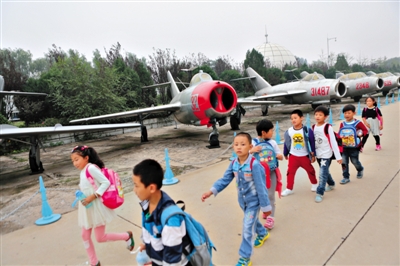 小学生在中国航空博物馆参观“少年先锋号”米格-15飞机。近日,该馆106架飞机被评为一级文物。本版图片/新京报记者 秦斌